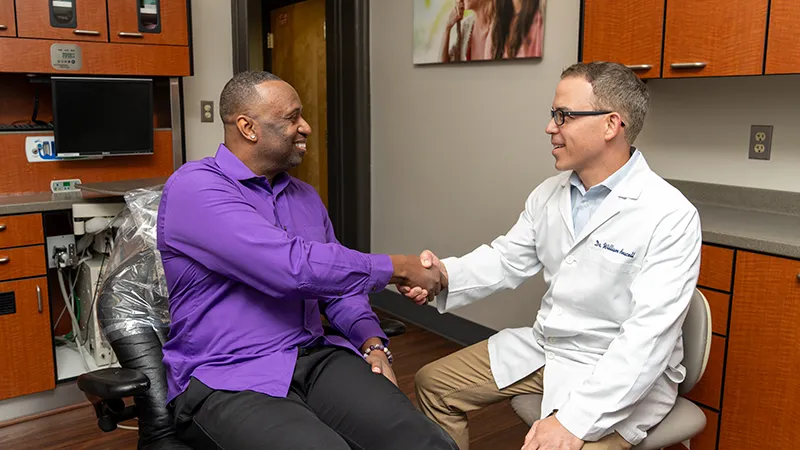 Dental patient shaking hands with dentist