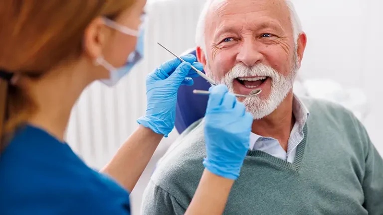 Older man getting a dental checkup with hygienist