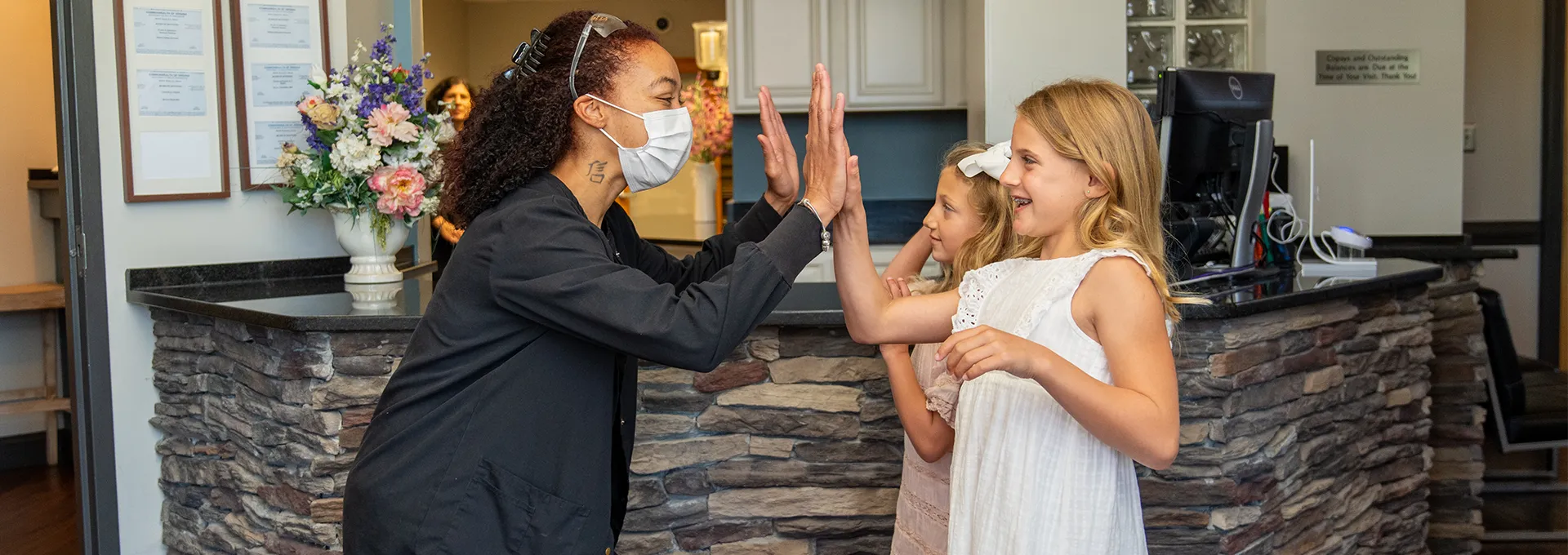 Dental Staff Member High-Fiving 2 Patients