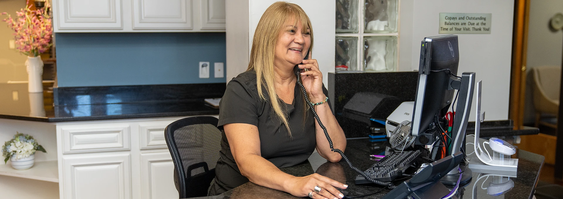 Dental Staff Member Taking a Call at the Front Desk